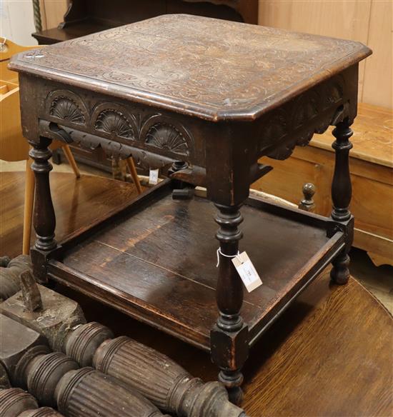 A carved oak two tier table W.61cm